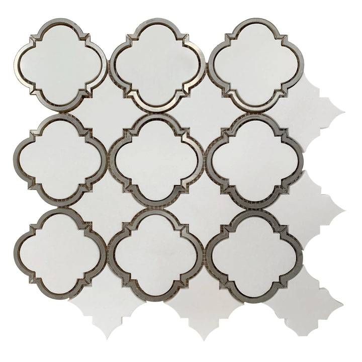 Close-up of Thassos Marble Waterjet Mosaic with Patterned Metal Trim – elegant polished tile combining luxury stone and metallic accents